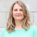 Das Foto zeigt die Landtagsabgeordnete Silke Backsen im Porträt vor einer hellgrauen Mauer. Silke trägt ein türkis Sweatshirt und offenen, schulterlange mittelblonde Haare